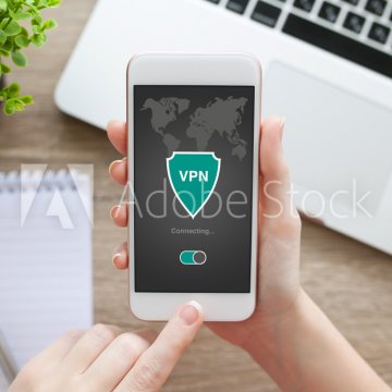 mobile vpn turbo vpn holding smartphone in hand with vpn on display laptop in the background notebook and pen